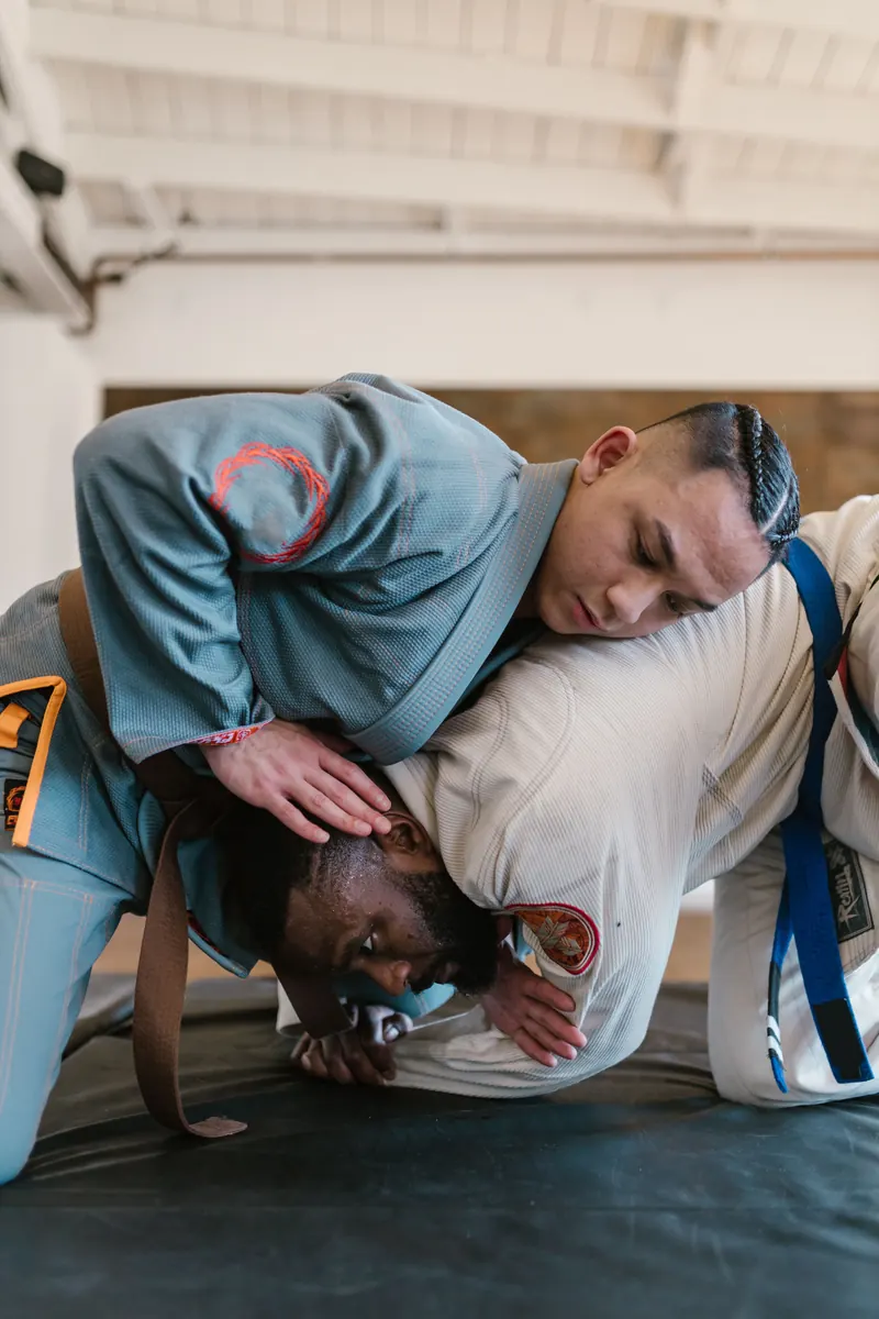 Två BJJ-utövare rullar lugnt i gi